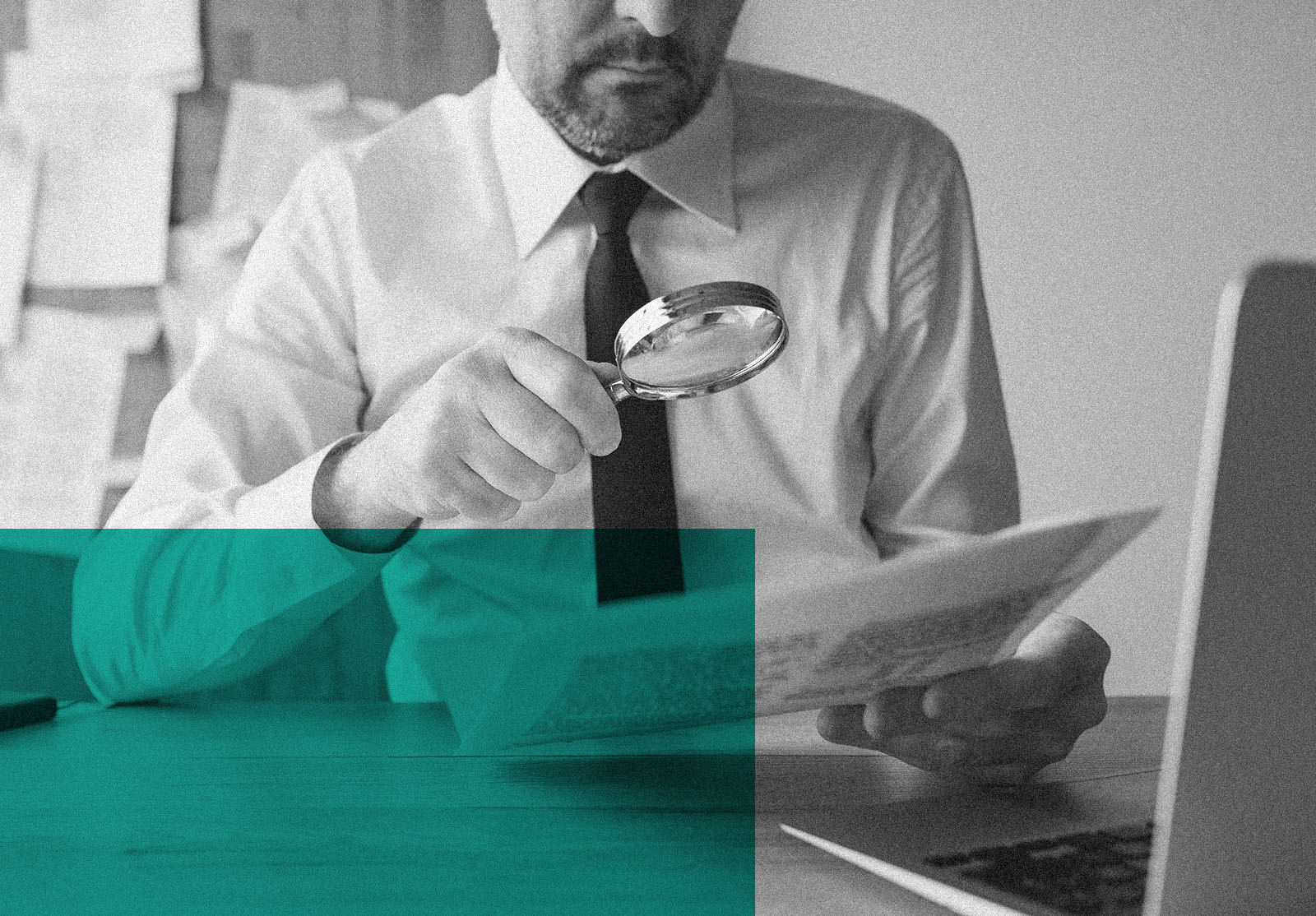 Businessman reading document contract papers with magnifying glass at office desk, close up with selective focus