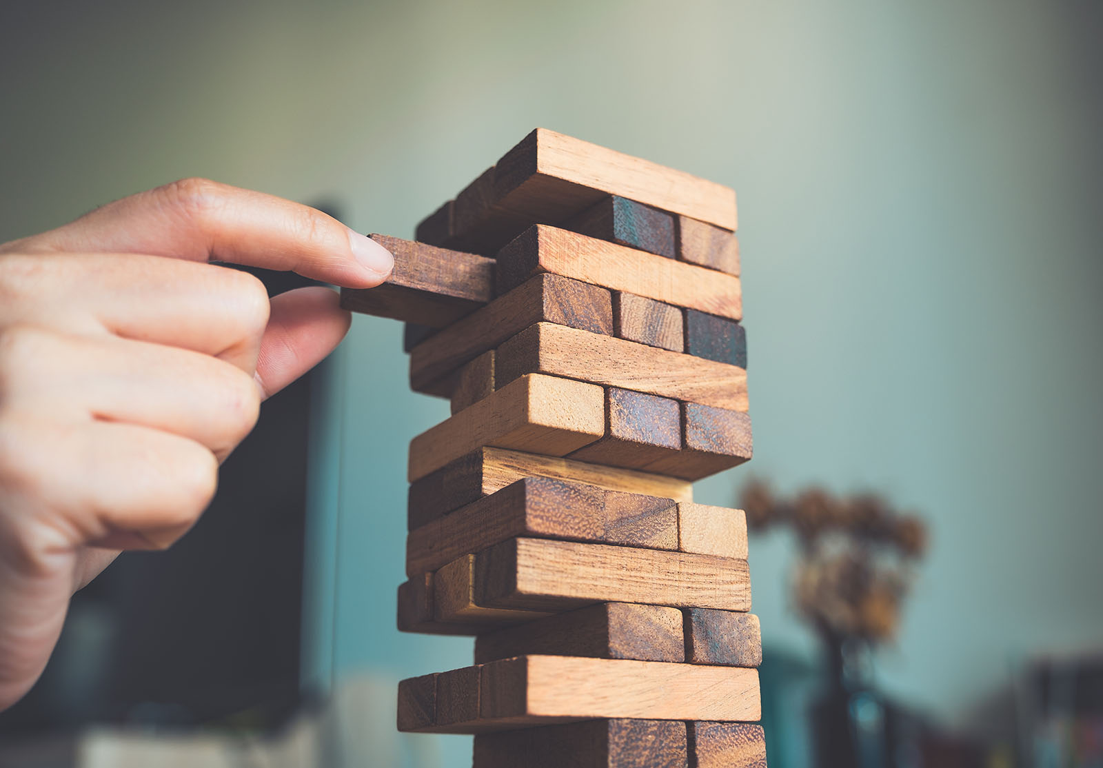 Gros plan d'une main tenant un jeu de blocs de bois Jenga ou Tumble tower.