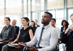 Des hommes et des femmes assistent à une conférence pour développer leur carrière.