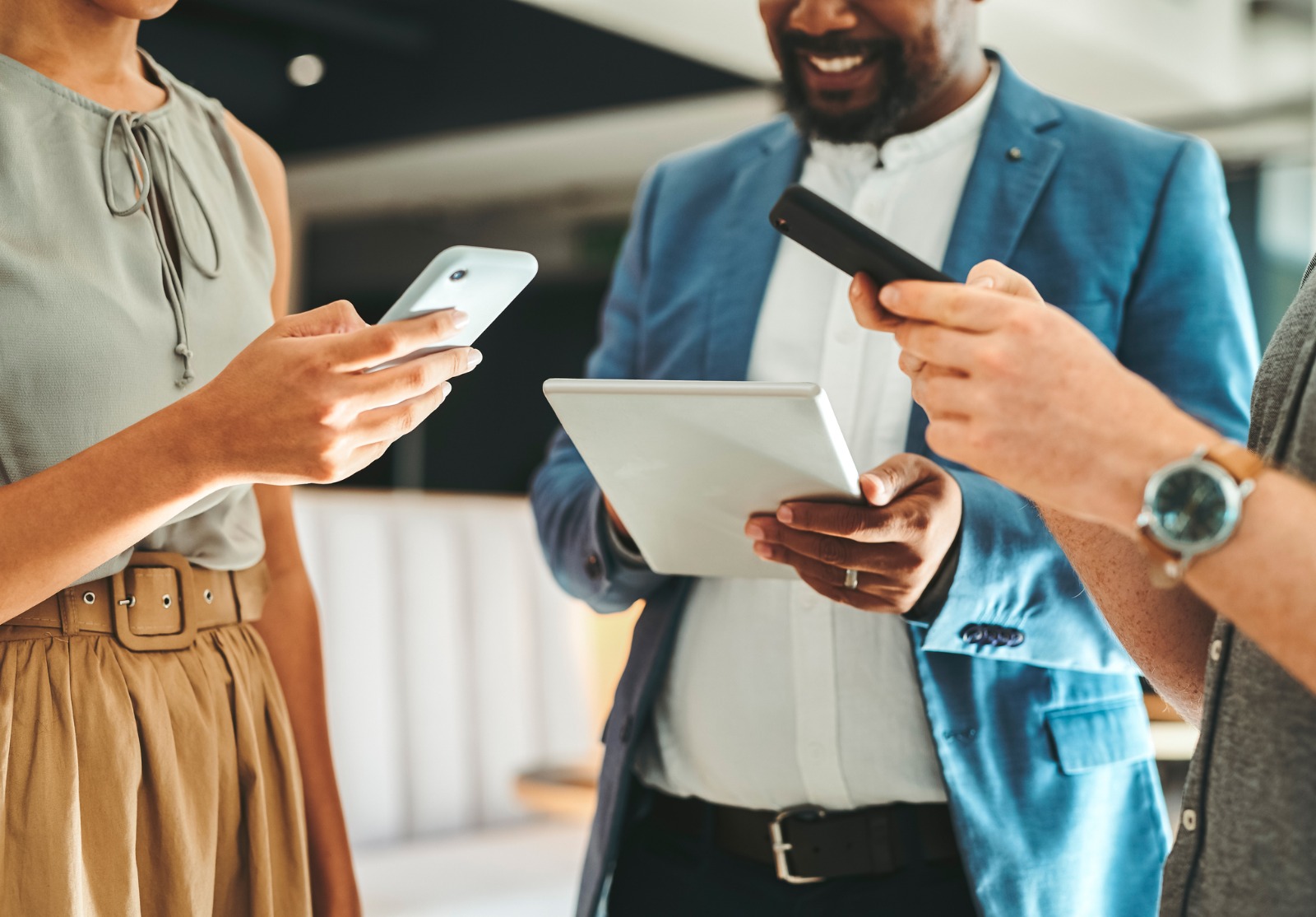 Diversité dans l’équipe de travail utilisant Internet sur les téléphones et les tablettes numériques pour la croissance du travail d’équipe au bureau.