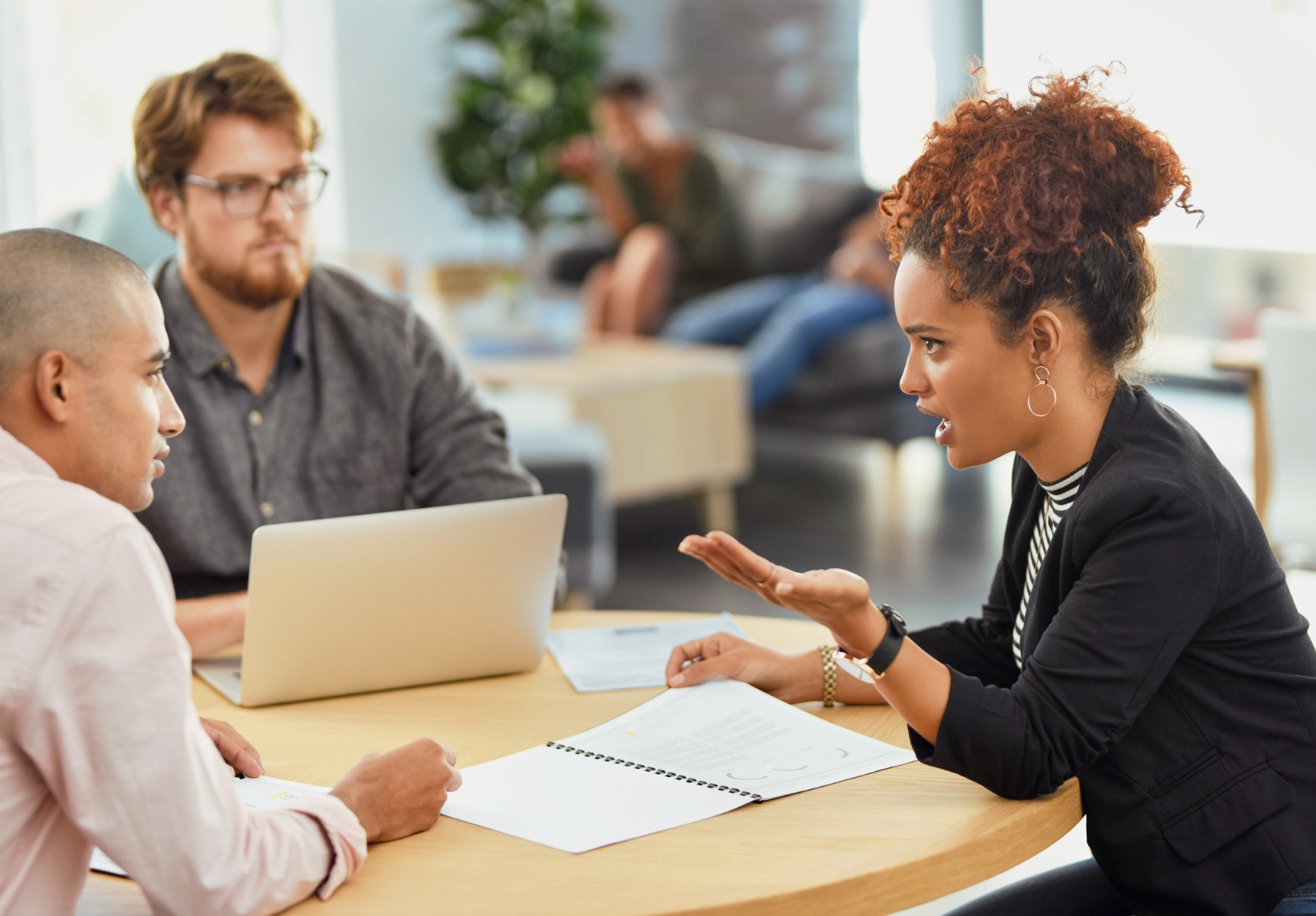 Trois personnes autour d'une table, clairement en train de discuter d'un problème.