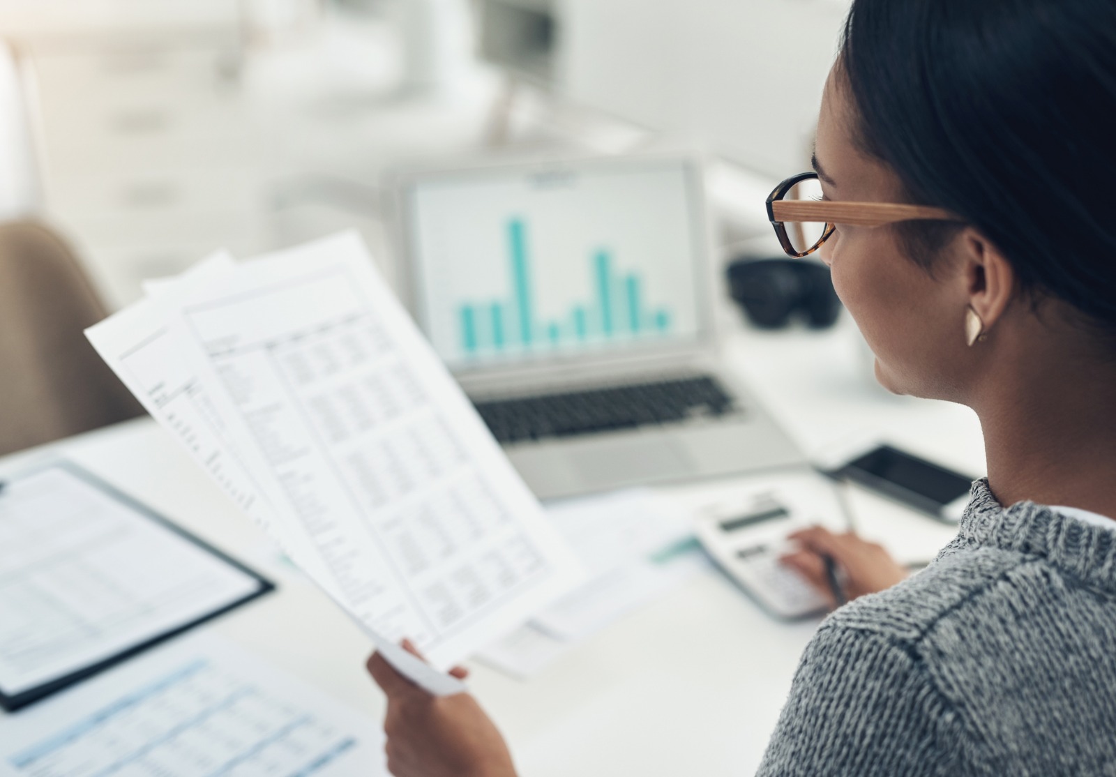 Gros plan d’une femme d’affaires méconnaissable calculant les finances dans un bureau.