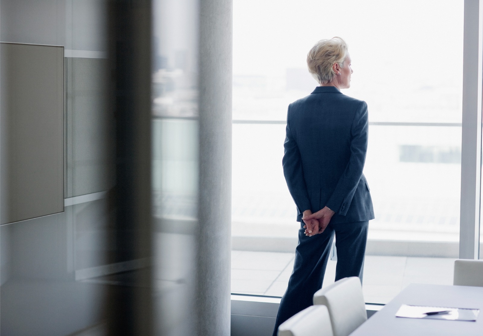 Femme d'affaires debout à la fenêtre dans le bureau.