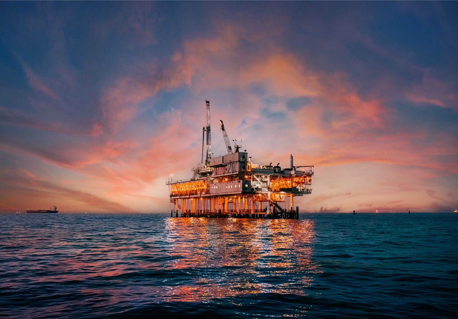 Ciel de coucher de soleil vibrant derrière une plate-forme de forage pétrolier offshore au large de la côte du comté d’Orange, en Californie