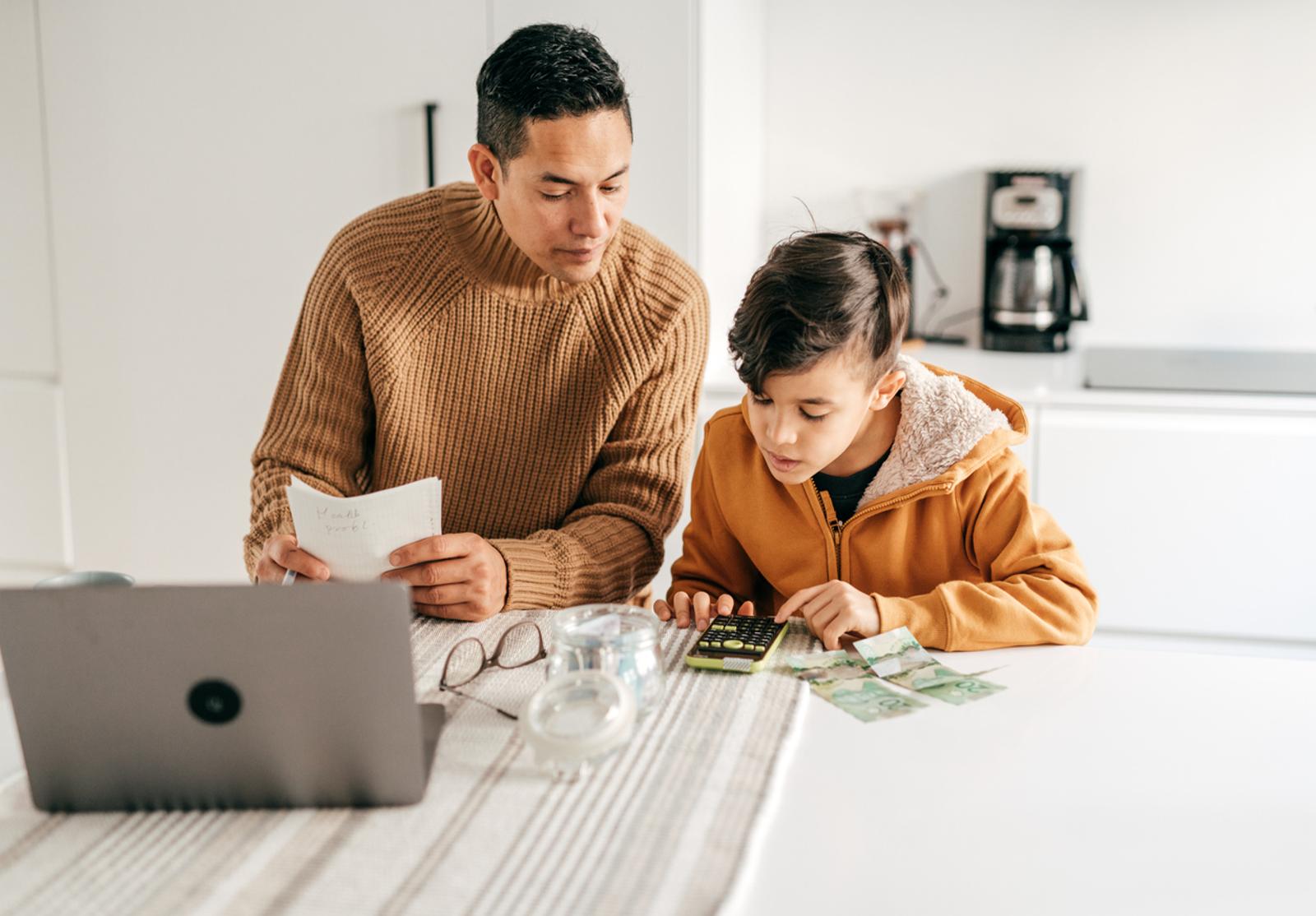 Un père enseigne à son fils à compter de l’argent à la maison.